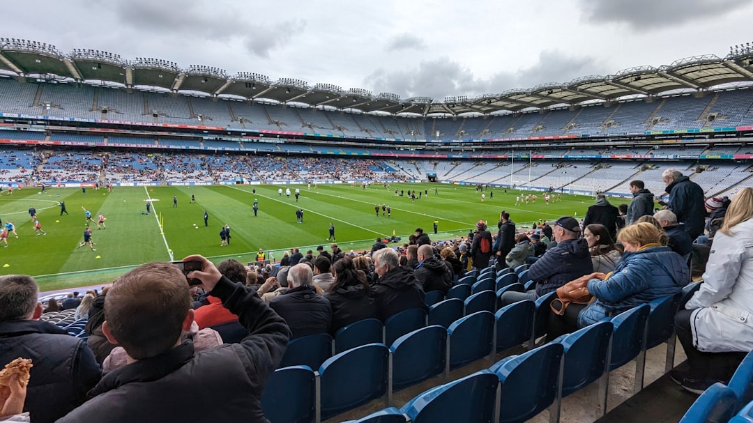 Spectators watch a gaelic football match in a stadium.