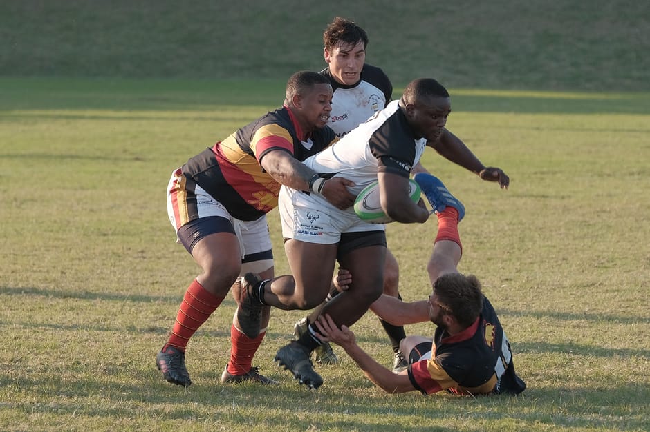 Rugby players tackling fiercely during a competitive match in South Africa.
