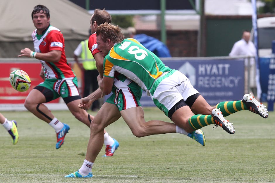 Players engaged in an intense rugby tackle during a competitive match outdoors.