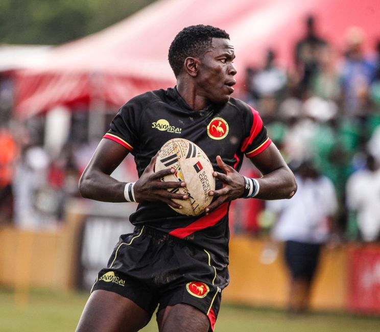 Rugby player in motion during an outdoor game, sporting team colors.