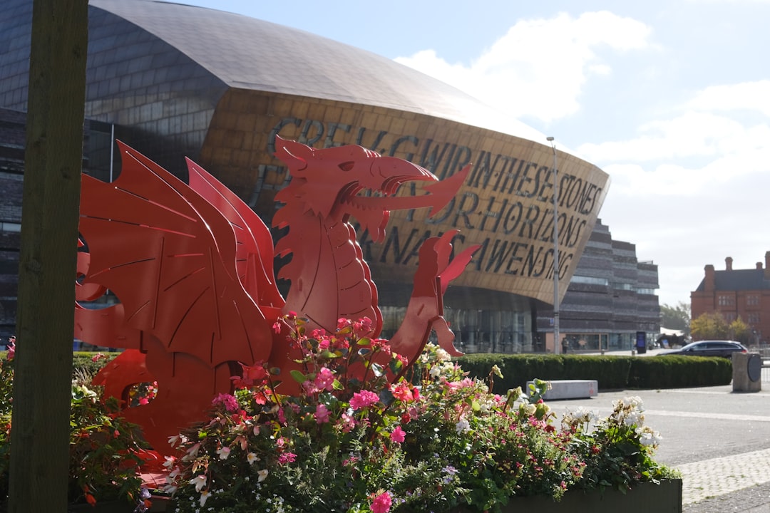Welsh red dragon statue in front of modern building.